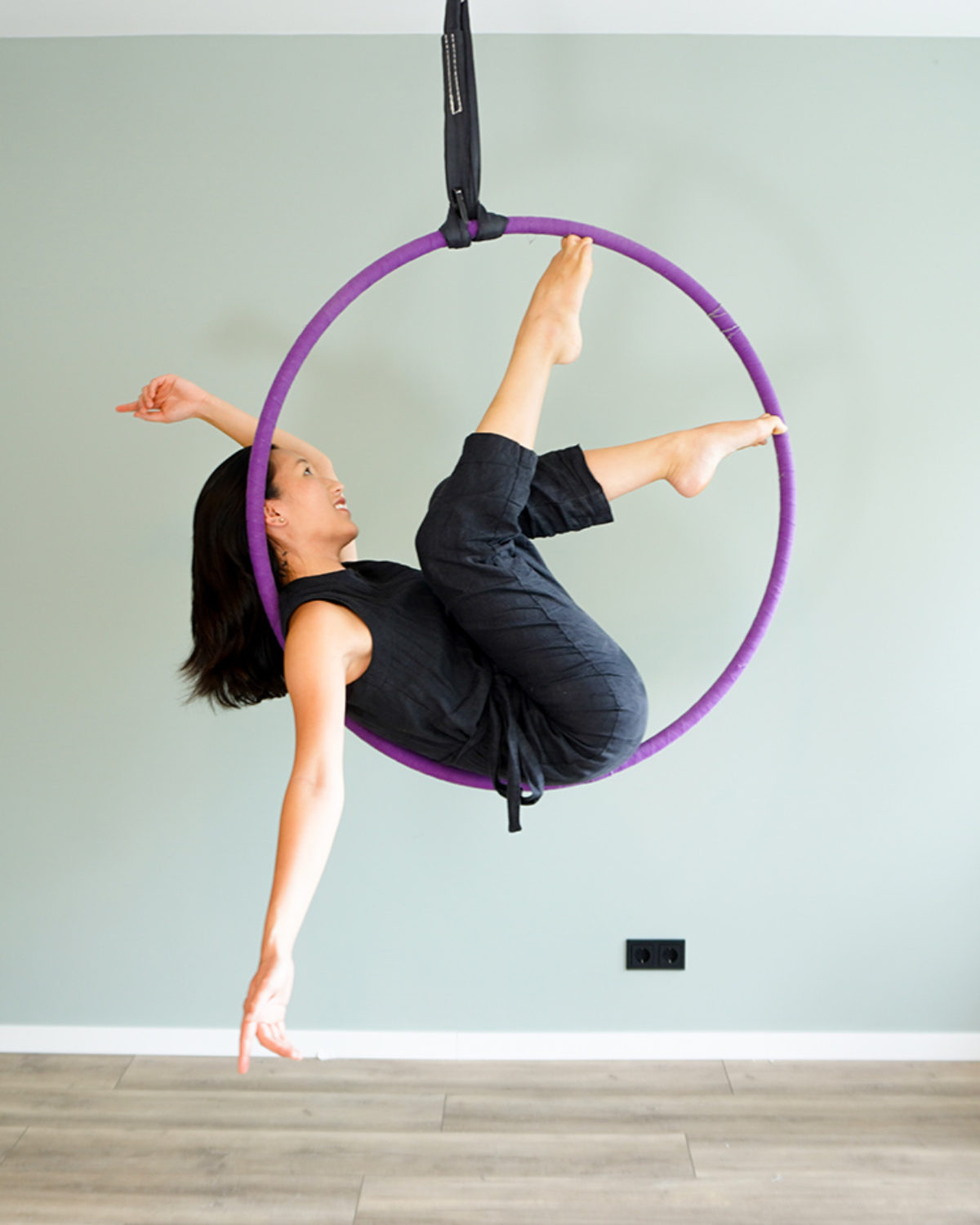 Full body of active barefoot female gymnast doing siren pose on hanging aerial  hoop or lyra against white background in light studio Stock Photo - Alamy